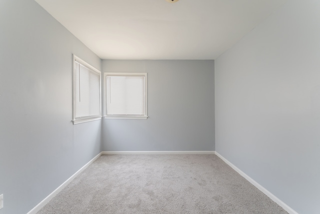 carpeted spare room featuring baseboards