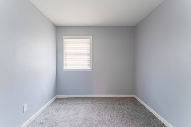 unfurnished room with carpet and baseboards