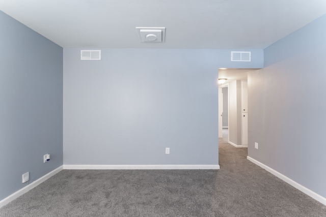 carpeted spare room featuring visible vents and baseboards