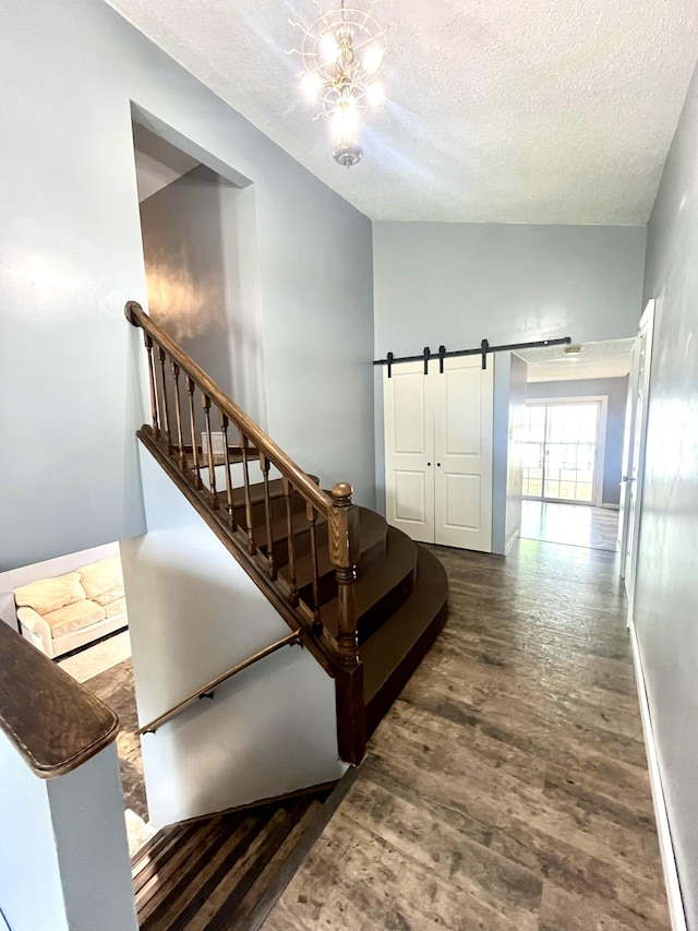 2264 Lynn Dr, Saint Joseph, MI 49085 - stairs featuring a textured ceiling, wood finished floors, a barn door, and a chandelier