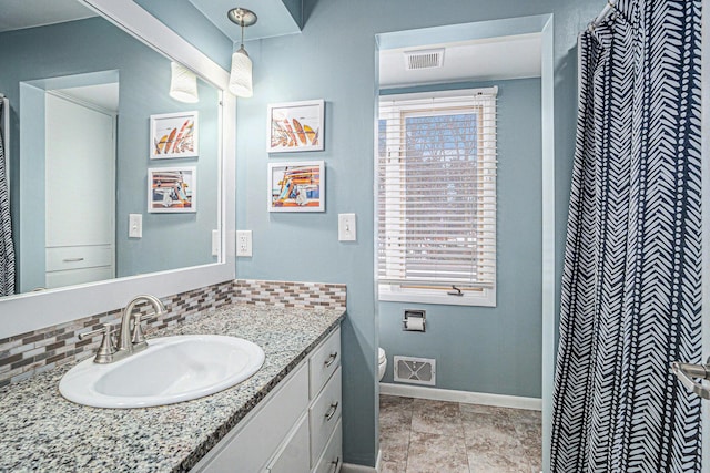 full bathroom with decorative backsplash, visible vents, vanity, and baseboards