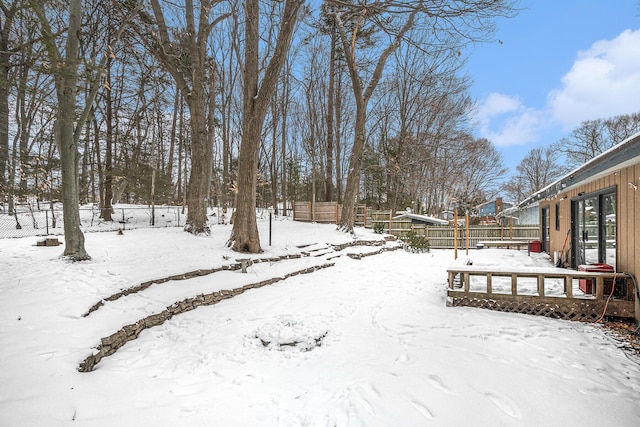 snowy yard featuring fence