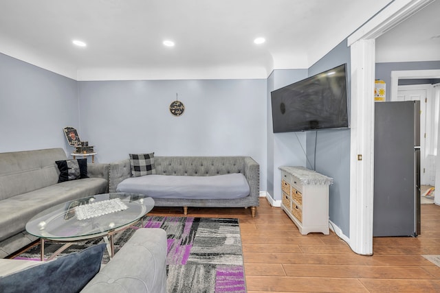 living area with baseboards, light wood-style flooring, and recessed lighting