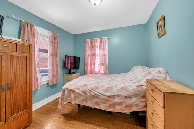 bedroom featuring light wood-style floors and baseboards