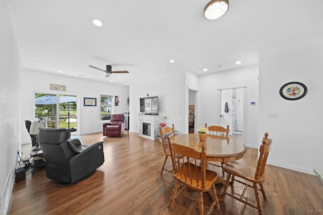 dining area featuring a fireplace, recessed lighting, a ceiling fan, wood finished floors, and baseboards