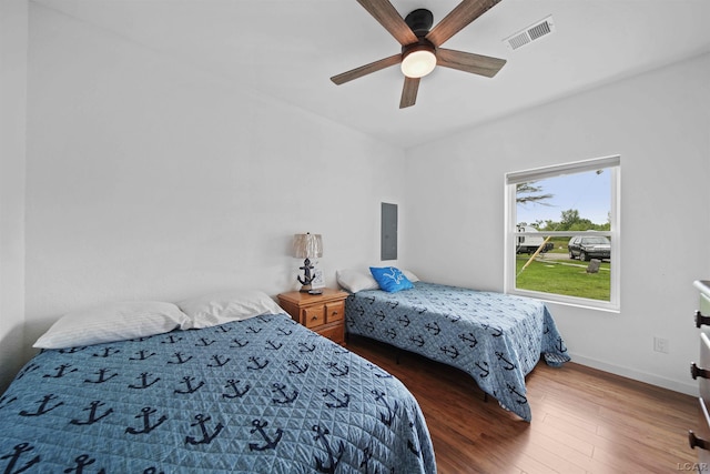 bedroom with a ceiling fan, visible vents, baseboards, electric panel, and dark wood-style floors