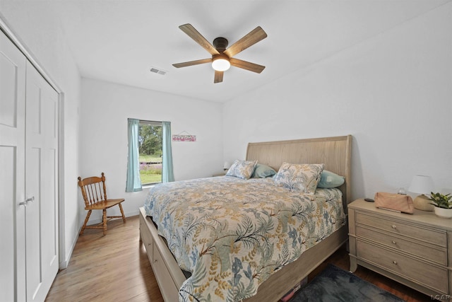 bedroom with ceiling fan, visible vents, baseboards, a closet, and light wood-type flooring