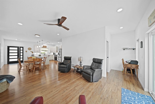 living room with light wood-style flooring, baseboards, a ceiling fan, and recessed lighting