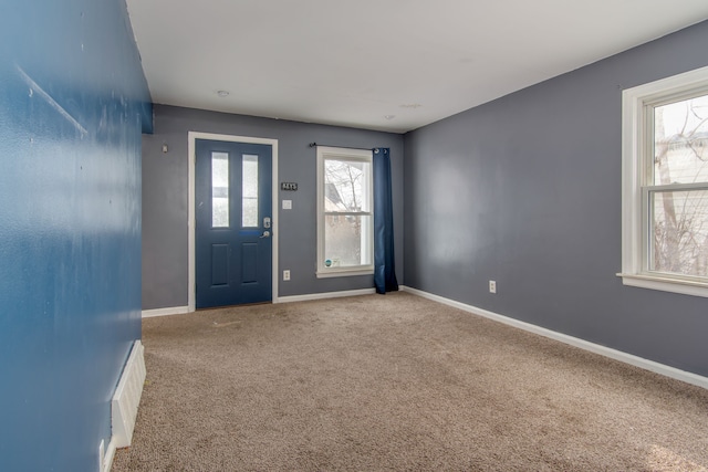 carpeted entrance foyer with visible vents, baseboards, and a healthy amount of sunlight