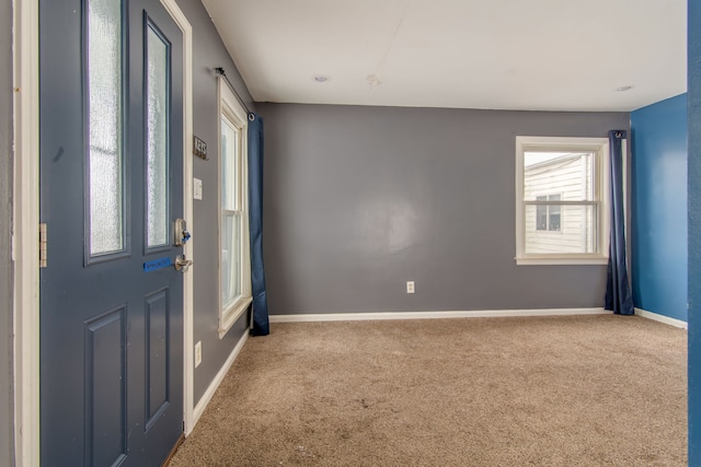 carpeted entryway featuring baseboards