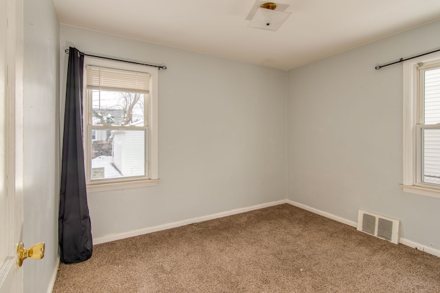 carpeted empty room with visible vents and baseboards