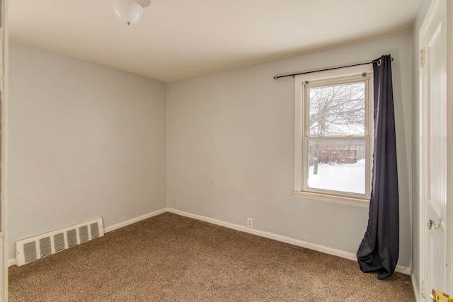 carpeted spare room featuring visible vents and baseboards