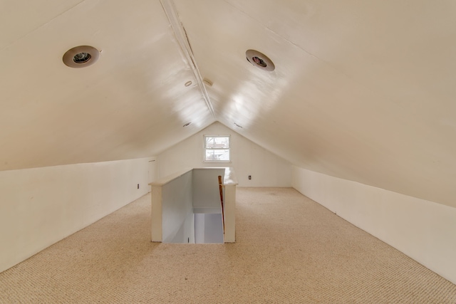 bonus room with lofted ceiling and carpet flooring