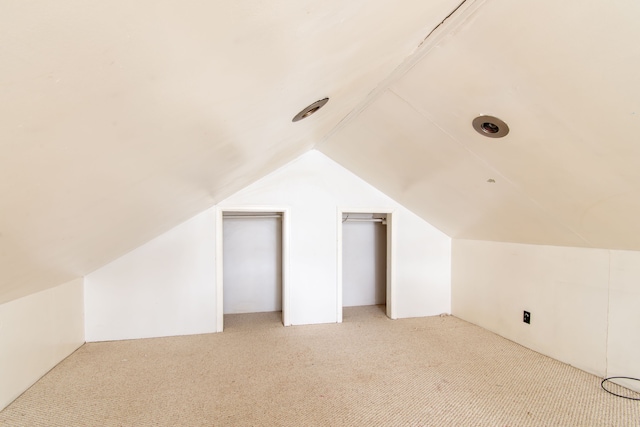 bonus room featuring lofted ceiling and light colored carpet