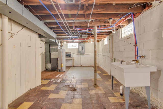 below grade area featuring water heater, a healthy amount of sunlight, electric panel, and a sink
