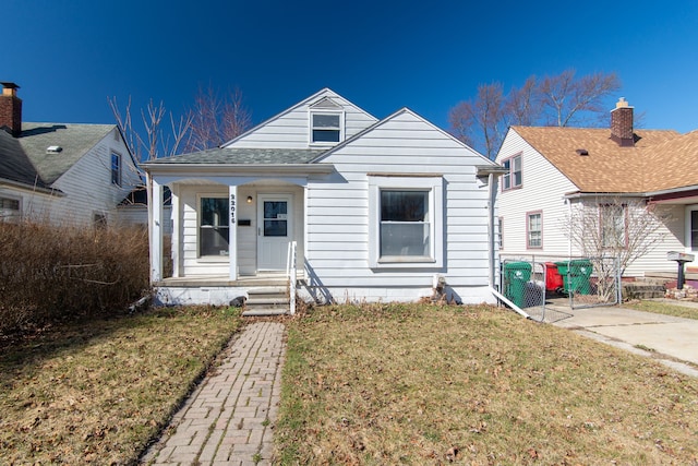 bungalow-style home featuring a porch, a front yard, and a shingled roof