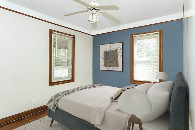 bedroom with ceiling fan, baseboards, and wood finished floors