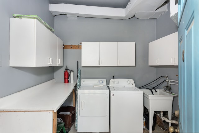 washroom featuring washing machine and dryer, cabinet space, and a sink