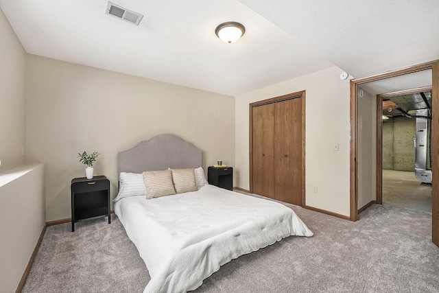 bedroom with a closet, visible vents, light carpet, and baseboards