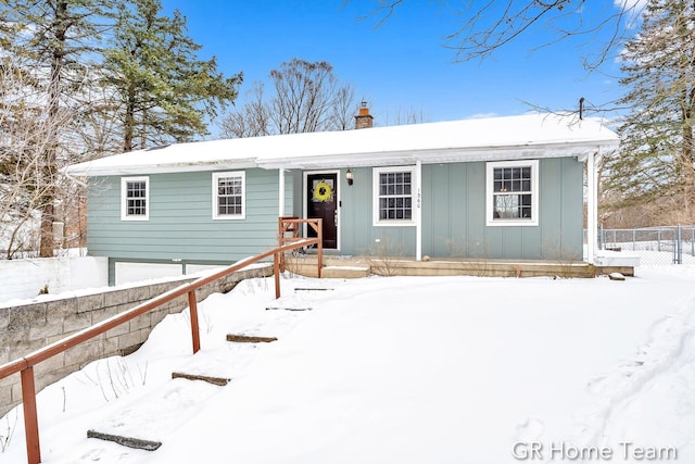 view of front of home with board and batten siding, fence, and a chimney