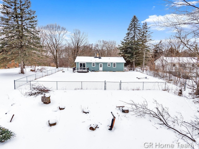 yard covered in snow with fence and a deck