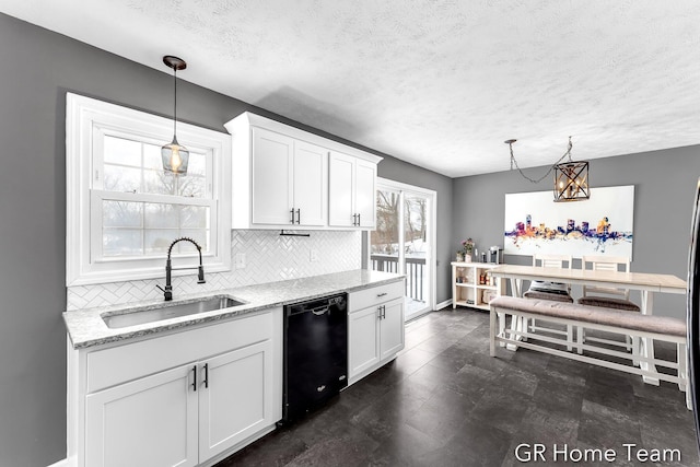 kitchen with black dishwasher, a sink, decorative light fixtures, and white cabinets