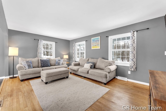 living area with visible vents, baseboards, and wood finished floors