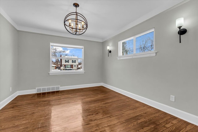 unfurnished dining area featuring dark wood-style flooring, crown molding, visible vents, a chandelier, and baseboards