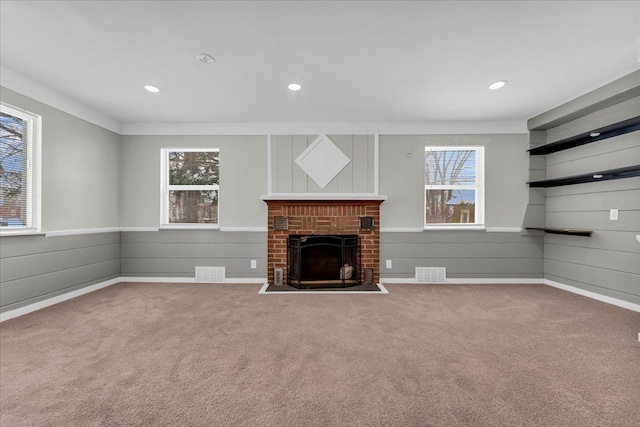 unfurnished living room with a brick fireplace, visible vents, and carpet flooring