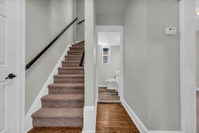 stairway featuring baseboards and wood finished floors