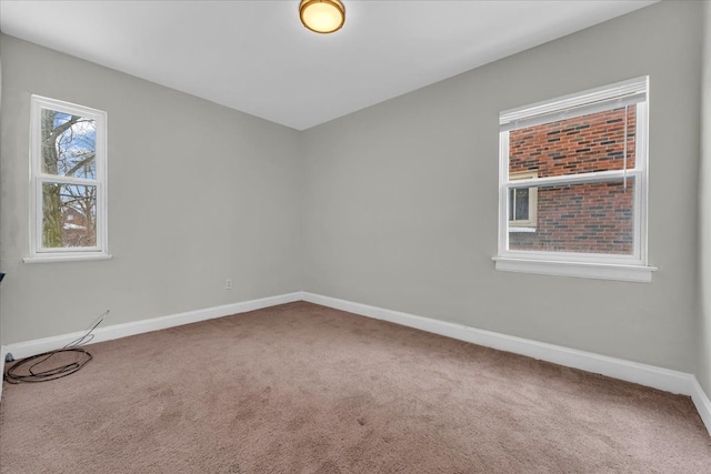 unfurnished room with carpet and baseboards