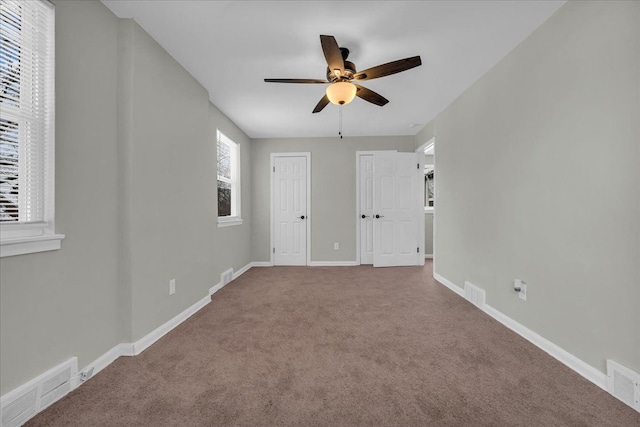 unfurnished bedroom with carpet, visible vents, and baseboards