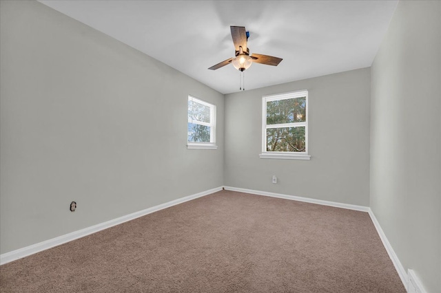 carpeted spare room featuring a ceiling fan and baseboards