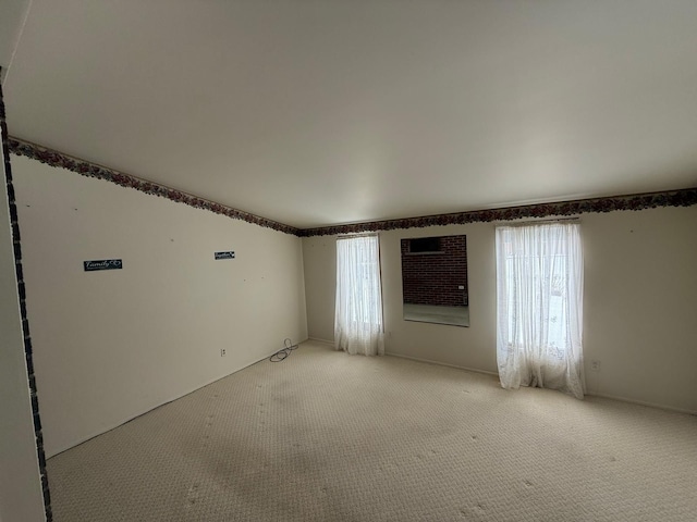 empty room with plenty of natural light and carpet flooring