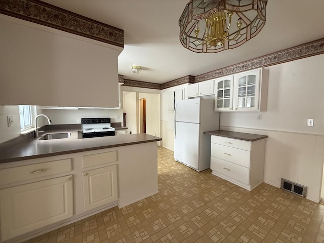 kitchen with electric range, visible vents, glass insert cabinets, freestanding refrigerator, and white cabinetry