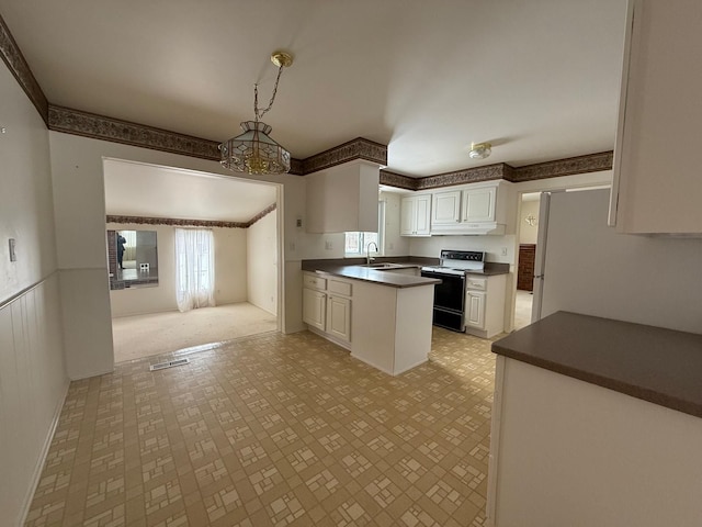 kitchen featuring range with electric stovetop, a sink, white cabinetry, hanging light fixtures, and dark countertops