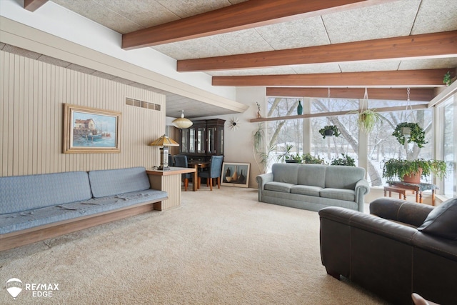 carpeted living room featuring visible vents and beamed ceiling