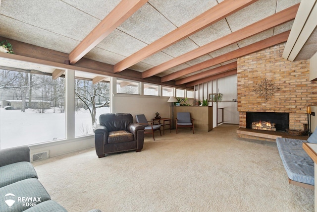 living area with carpet, a brick fireplace, visible vents, and lofted ceiling with beams