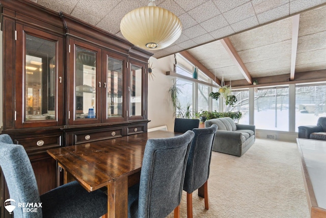 dining area with carpet floors, visible vents, and lofted ceiling with beams