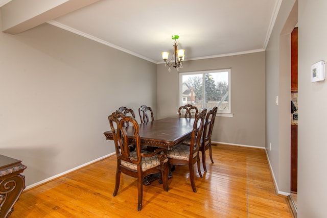 dining area featuring an inviting chandelier, baseboards, ornamental molding, and light wood finished floors