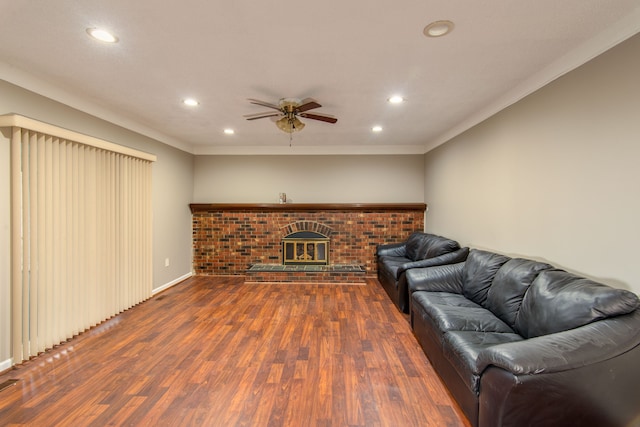 living room featuring ceiling fan, a fireplace, wood finished floors, and recessed lighting