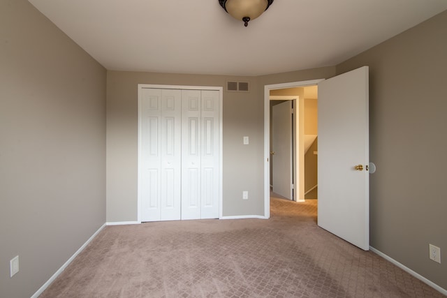 unfurnished bedroom featuring carpet, a closet, visible vents, and baseboards