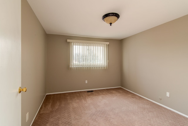 empty room featuring carpet flooring, visible vents, and baseboards