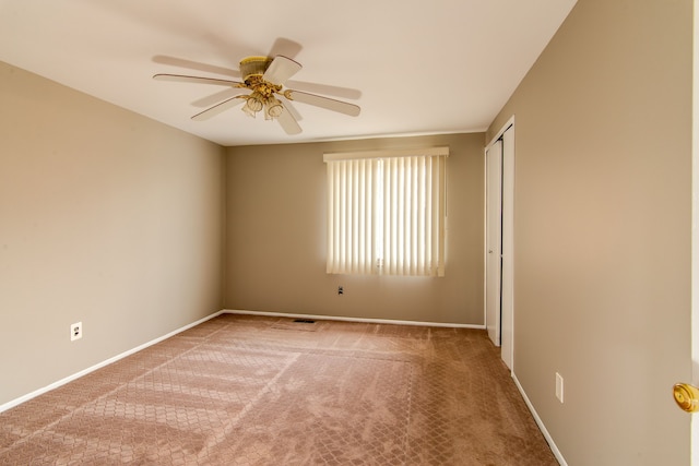 unfurnished room with carpet floors, a ceiling fan, and baseboards