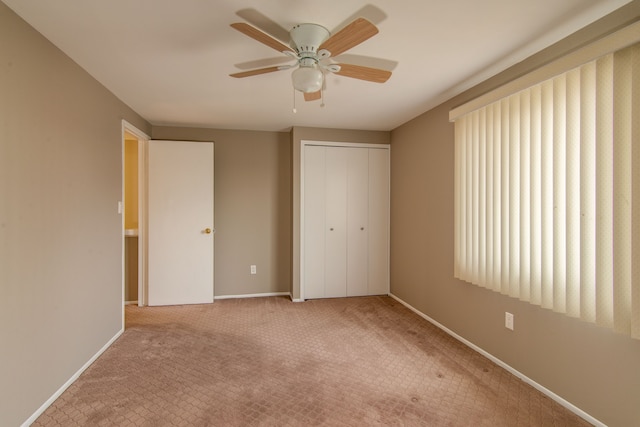 unfurnished bedroom featuring a ceiling fan, a closet, baseboards, and carpet flooring