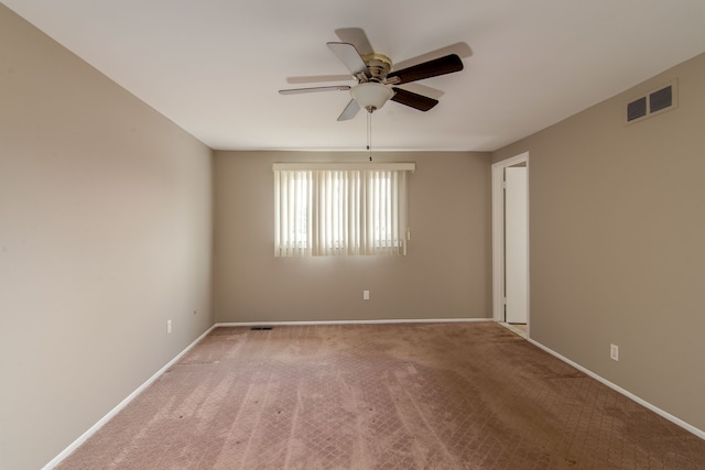 carpeted empty room with visible vents, ceiling fan, and baseboards