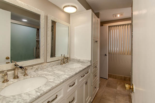 full bathroom with double vanity, a sink, visible vents, and baseboards