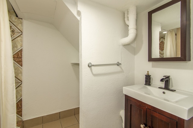 bathroom with baseboards, vanity, and tile patterned floors