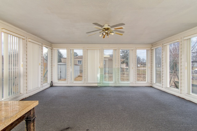 unfurnished sunroom featuring ceiling fan