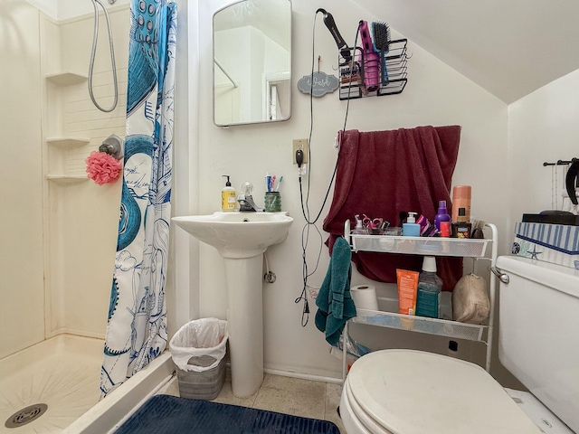 full bath featuring tile patterned flooring, vaulted ceiling, a shower stall, and toilet